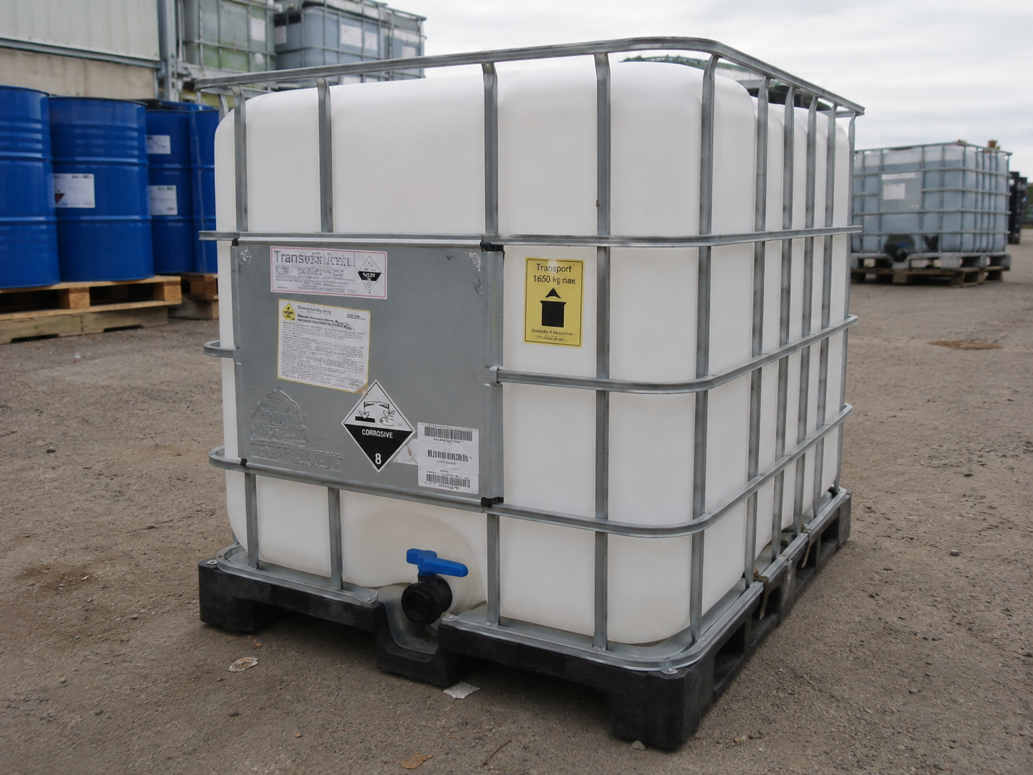 The yard — caged composite IBC totes staged for pickup